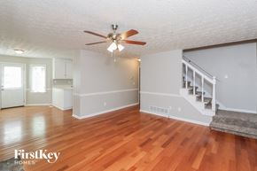 Dallas house for rent - A spacious room with wooden floors and a staircase.