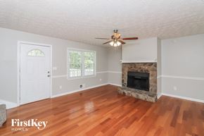 Dallas house for rent - A room with a fireplace and a ceiling fan.