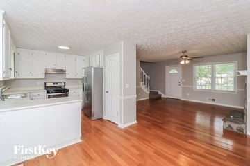 Dallas house for rent - A kitchen with white cabinets and a wooden floor.
