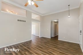 Kansas City house for rent - A spacious room with wooden floors and a ceiling fan.