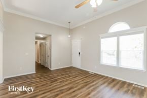 Kansas City house for rent - A spacious room with wooden floors and a ceiling fan.