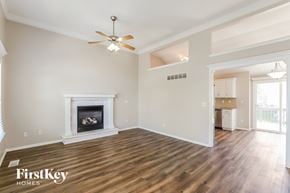 Kansas City house for rent - A spacious living room with a fireplace and wood flooring.