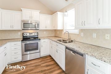 Kansas City house for rent - A kitchen with white cabinets and a stainless steel dishwasher.