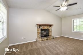 Flowery Branch house for rent - a living room with a fireplace and a ceiling fan