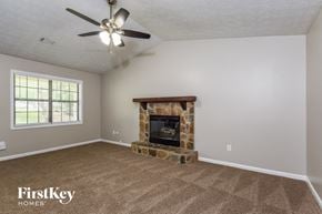 Flowery Branch house for rent - a living room with a fireplace and a ceiling fan