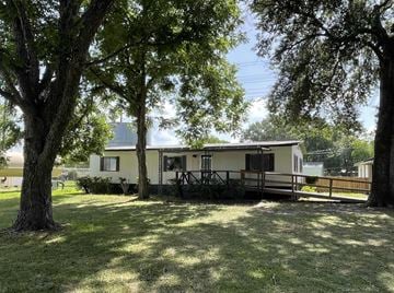 Cypress house for rent - A house with a porch surrounded by trees.