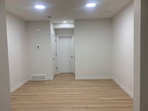 Edmonton apartment for rent - a hallway with wood floors and white walls and a door