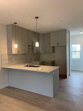 Edmonton apartment for rent - an empty kitchen with white cabinets and a sink