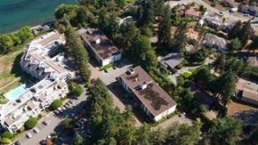 Nanaimo apartment for rent - An aerial view of a resort with a swimming pool and a parking lot.