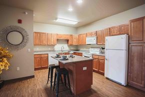 Watford City apartment for rent - A kitchen with wooden cabinets and a white refrigerator.