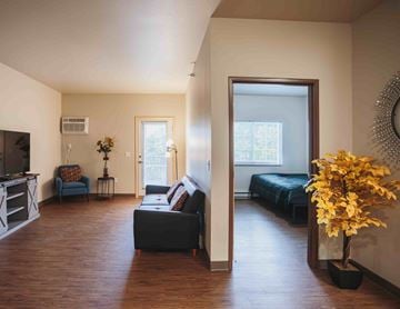 Watford City apartment for rent - A living room with a black couch and a wooden floor.