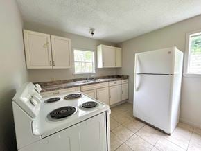 Bay City house for rent - A kitchen with a white stove and refrigerator.
