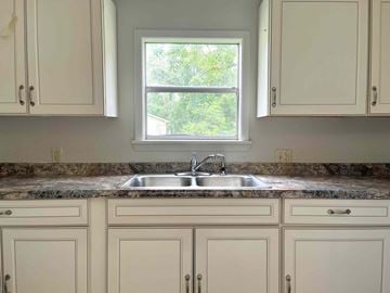 Bay City house for rent - A kitchen with a sink and cabinets.