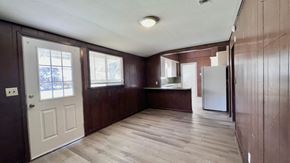 Bay City house for rent - an empty kitchen with wooden cabinets and a white door