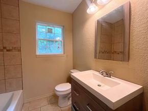 Bay City house for rent - A bathroom with a toilet, sink, and tub.