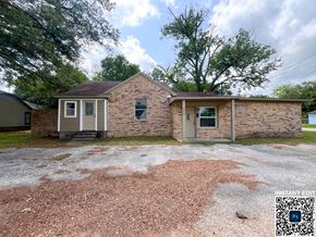 Bay City house for rent - A brick house with a gravel driveway in front.