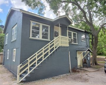Bay City house for rent - A house with a grey exterior and a wooden staircase leading to the second floor.