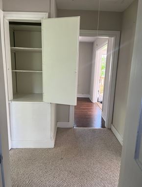 Bay City house for rent - A white open cupboard in a room with a carpeted floor.