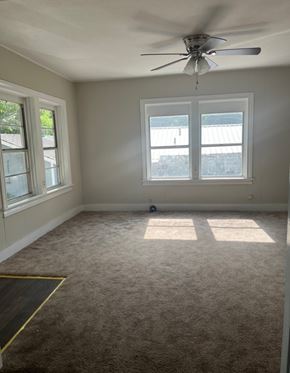 Bay City house for rent - A room with a ceiling fan and two windows.