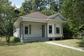 Bay City house for rent - a small white house with a yard and trees