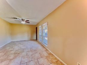 Bay City house for rent - an empty living room with a ceiling fan and a window
