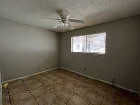 Bay City house for rent - an empty living room with a ceiling fan and a window