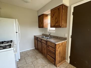 Bay City house for rent - an empty kitchen with wooden cabinets and a sink