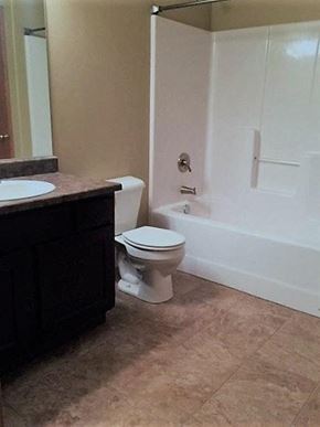Brandon apartment for rent - A white toilet sits in a bathroom next to a sink.