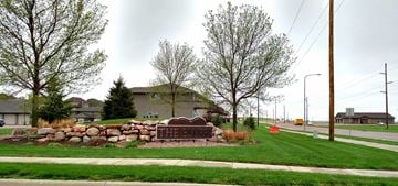 Brandon apartment for rent - A residential street with houses on both sides and a stone wall in the middle.