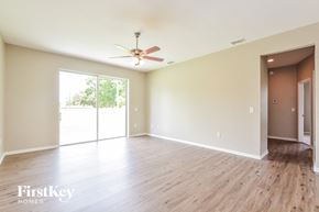 Winter Haven house for rent - A spacious room with a ceiling fan and sliding glass doors leading to a balcony.