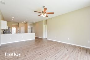 Winter Haven house for rent - A spacious room with a ceiling fan and wooden flooring.