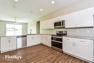 Winter Haven house for rent - A kitchen with white cabinets and a FirstKey Homes logo.