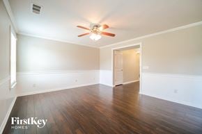 Nashville house for rent - A room with a ceiling fan and wooden floors.