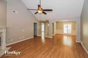 Cordova house for rent - A spacious room with a fireplace and wood flooring.
