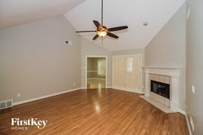 Cordova house for rent - A spacious room with a fireplace and a ceiling fan.