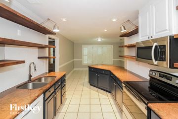 Cordova house for rent - A kitchen with a sink, stove, and microwave.