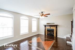 Clarksville house for rent - a living room with a fireplace and a ceiling fan