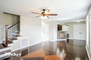 Clarksville house for rent - an empty living room with a ceiling fan and a staircase