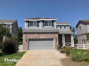 Aurora house for rent - a brick house with a garage door in front of it