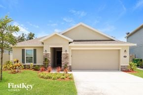 West Melbourne house for rent - a beige house with a garage door and a lawn