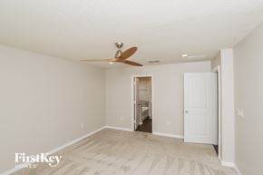 West Melbourne house for rent - a living room with a ceiling fan and a door to a bathroom