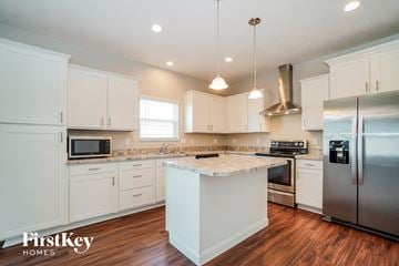 Canal Winchester house for rent - A kitchen with white cabinets and a wooden island.