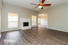 Saginaw house for rent - a living room with a fireplace and a ceiling fan