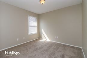 Saginaw house for rent - a bedroom with a carpeted floor and a window