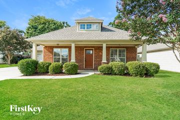 Calera house for rent - a small brick house with a front porch and a lawn