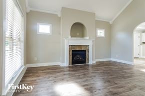 Calera house for rent - an empty living room with a fireplace and a window