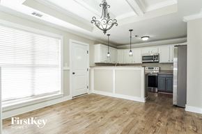 Calera house for rent - a kitchen with white cabinets and a large window