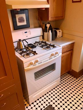 Minneapolis apartment for rent - A white gas stove with a kettle on it.