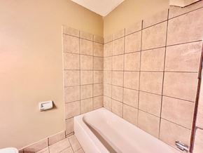 Bay City house for rent - a bathroom with beige tile and a tub and a sink