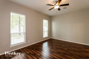Spring house for rent - A room with wooden floors and a ceiling fan.
